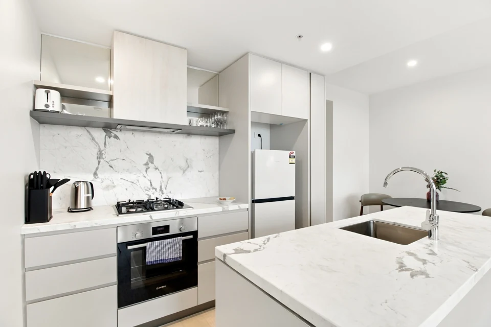 Bright white apartment kitchen with marble-effect surfaces